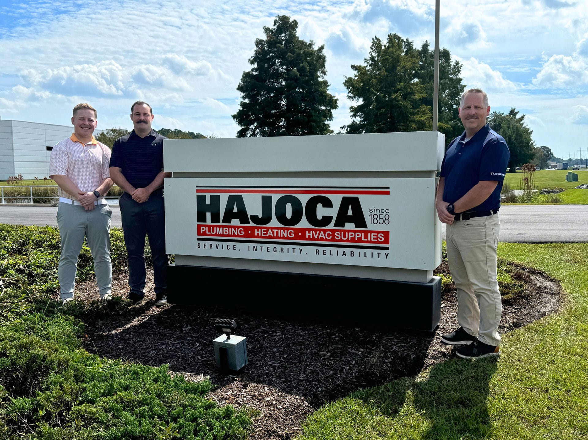Hajoca Wilmington NC teammates standing by Hajoca location sign